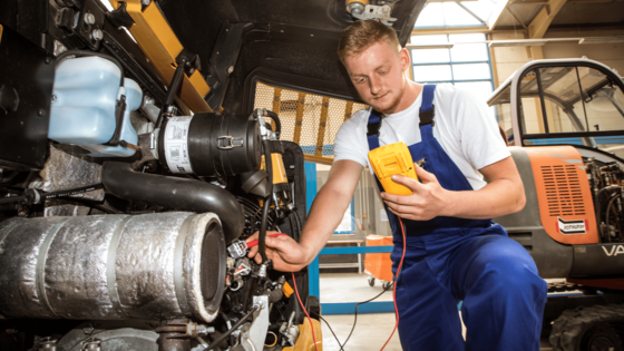 Auszubildender Land- und Baumaschinenmechatroniker überprüft die Funktionsfähigkeit der Maschine