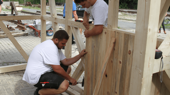 Auszubildende arbeiten gemeinsam an dem Bau eines Pavillons